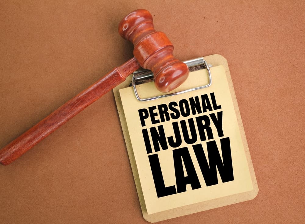 A judge's gavel and a blackboard with the words "Personal Injury Law" written on it, representing a legal concept.