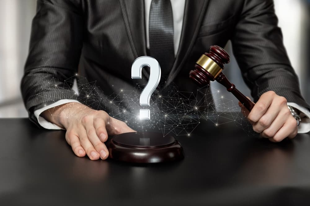 A personal injury attorney with gavel in hand and with a question mark