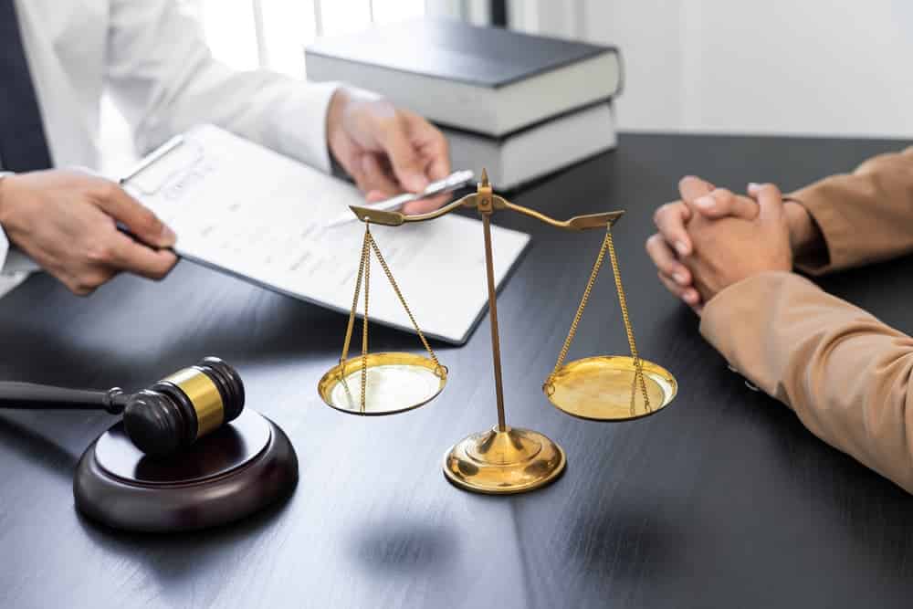 A lawyer or judge presents a client with contract documents, symbolizing law and legal services, including guidance, representation, and dispute resolution.