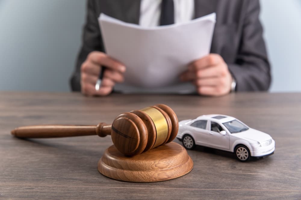 Model of car and gavel. Accident lawsuit or insurance.